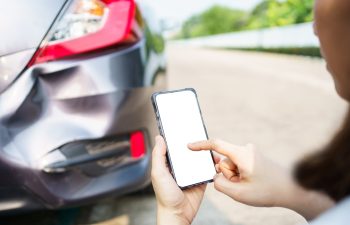 Asian woman got a car accident or car crash and using smartphone to call for road side emergency service. Woman texting on smartphone to call insurance assistant service.